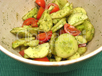 Gurken und Tomaten mit Salatdressing in Keramikschale