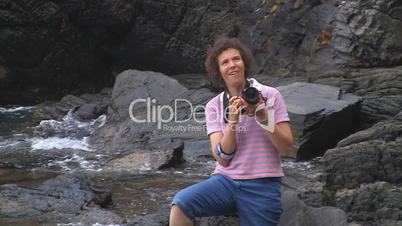 Frau fotografiert vor Küste