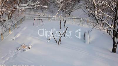 pan from playground to winter trees at sunny morning