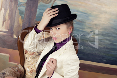 Beautiful young blond woman in black hat.