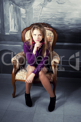Sexy blond girl  sitting on a luxury armchair
