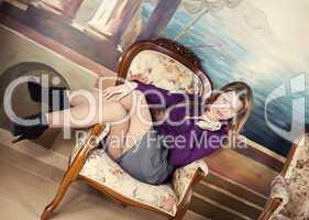 Sexy blond girl  sitting on a luxury armchair