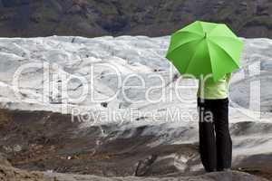 Environmental Concept Of A Woman With Green Umbrella By Glacier