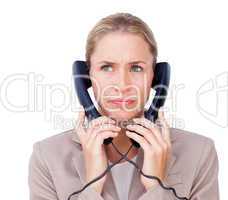 Stressed businesswoman tangled up in phone wires