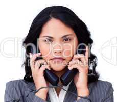 Annoyed businesswoman tangled up in phone wires