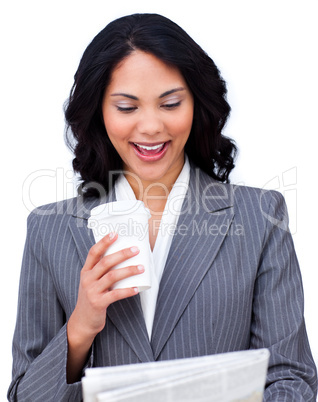 Young businesswoman drinking a coffee while reading a newspaper