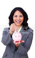 Cheerful businesswoman saving money in a piggybank