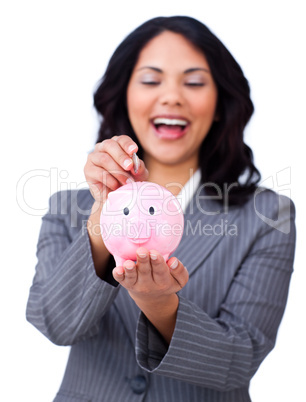 Laughing businesswoman saving money in a piggybank
