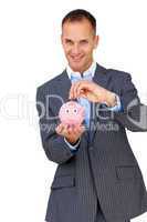 Confident businessman saving money in a piggybank