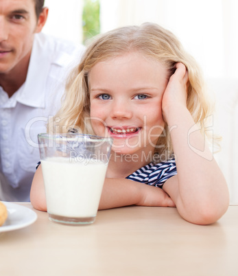 Smiling little girl drinking milk