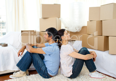 Tired couple relaxing while moving house