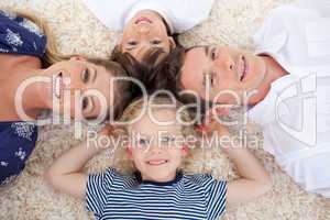 Smiling young family lying on the floor