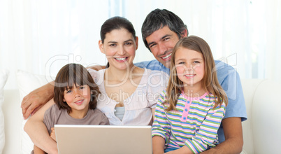Happy family using a laptop on the sofa