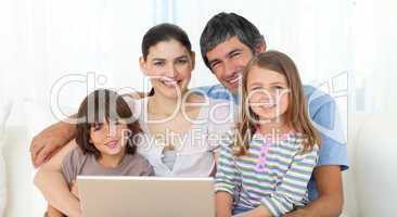 Happy family using a laptop on the sofa