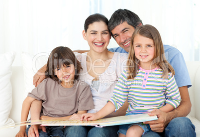 Joyful family reading together on the sofa