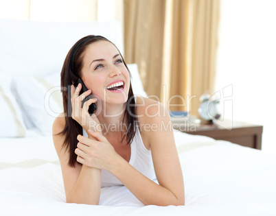 woman on phone lying on her bed