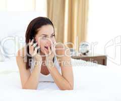 woman on phone lying on her bed