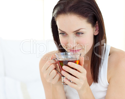 Delighted woman drinking a tea