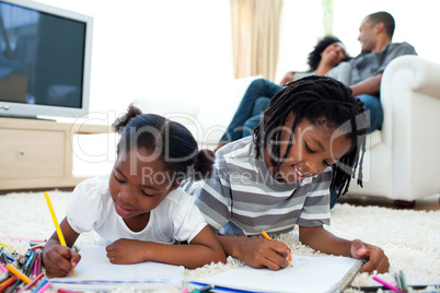 Lively children drawing lying on the floor