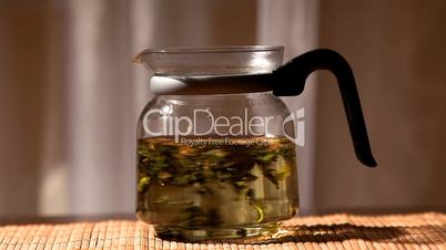 green tea brew in glass teapot