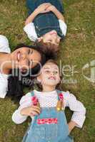 Happy mother and her children lying on the grass