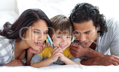 Joyful parents listening to music with their son