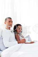 Loving couple drinking a coffee on their bed