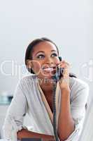 Smiling young businesswoman on phone looking upward