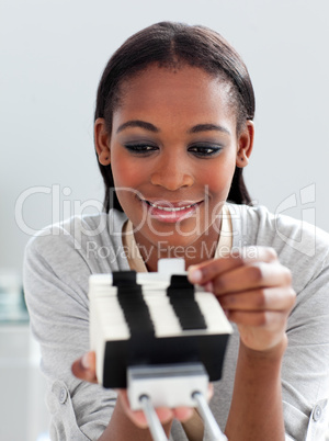 Positive businesswoman consulting a business card holder