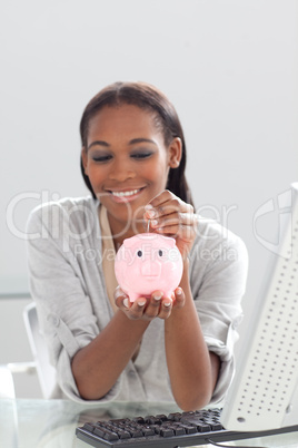 Afro-american businesswoman saving money in a piggybank