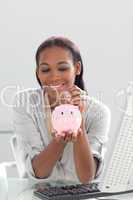 Afro-american businesswoman saving money in a piggybank