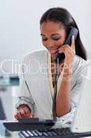 Assertive ethnic businesswoman talking on a phone