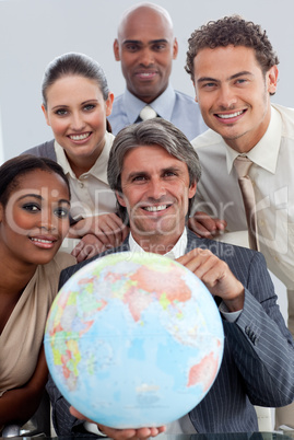 Cheerful Multi-ethnic business team showing a terrestrial globe