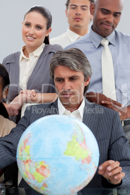 Multi-ethnic business people around a terrestrial globe