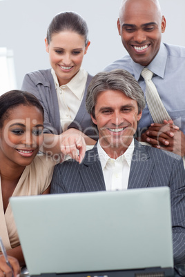 A business team showing ethnic diversity using a laptop