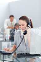 Smiling businesswoman on phone at her desk