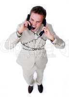 Furious businessman tangle up in phone wires