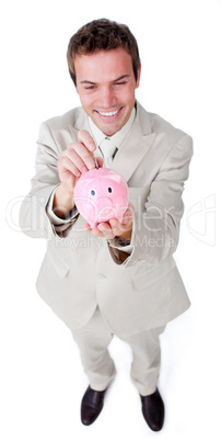 Cheerful businessman saving money in a piggybank