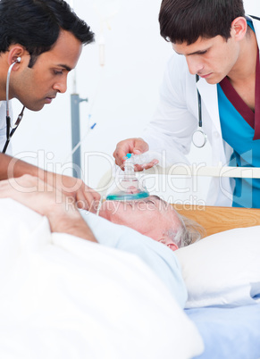 A doctor putting oxygen mask on a senior patient