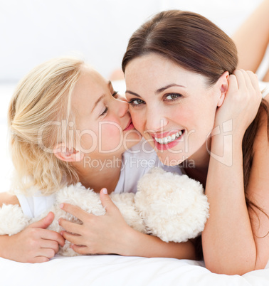 Close-up of a blond little girl kissing her mother