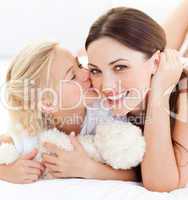 Close-up of a blond little girl kissing her mother