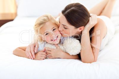 Attractive mother kissing her little girl