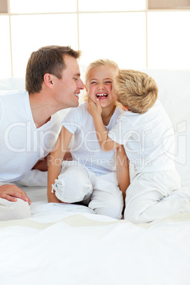 Cute siblings playing with their father