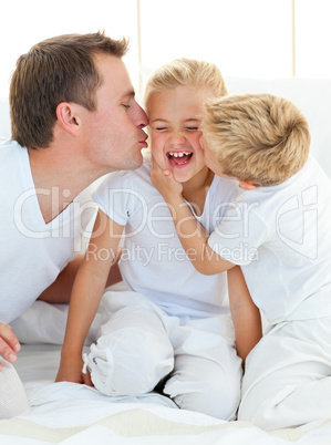 Loving family playing sitting on a bed