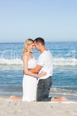 Enamoured couple kissing at the shore line