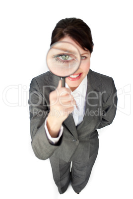 Young businesswoman looking through magnifying glass