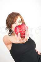 Beautiful girl holding a red apple, extended toward camera