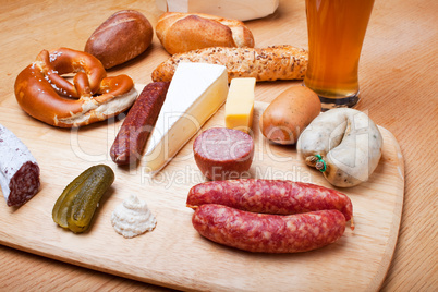 Wurst, Brot und ein Weißbier auf einem Eichentisch