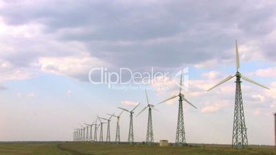 HD group of spinning wind turbines on the background of cloudscape, wide