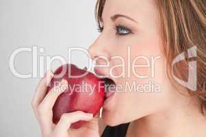 Beautiful girl biting red apple